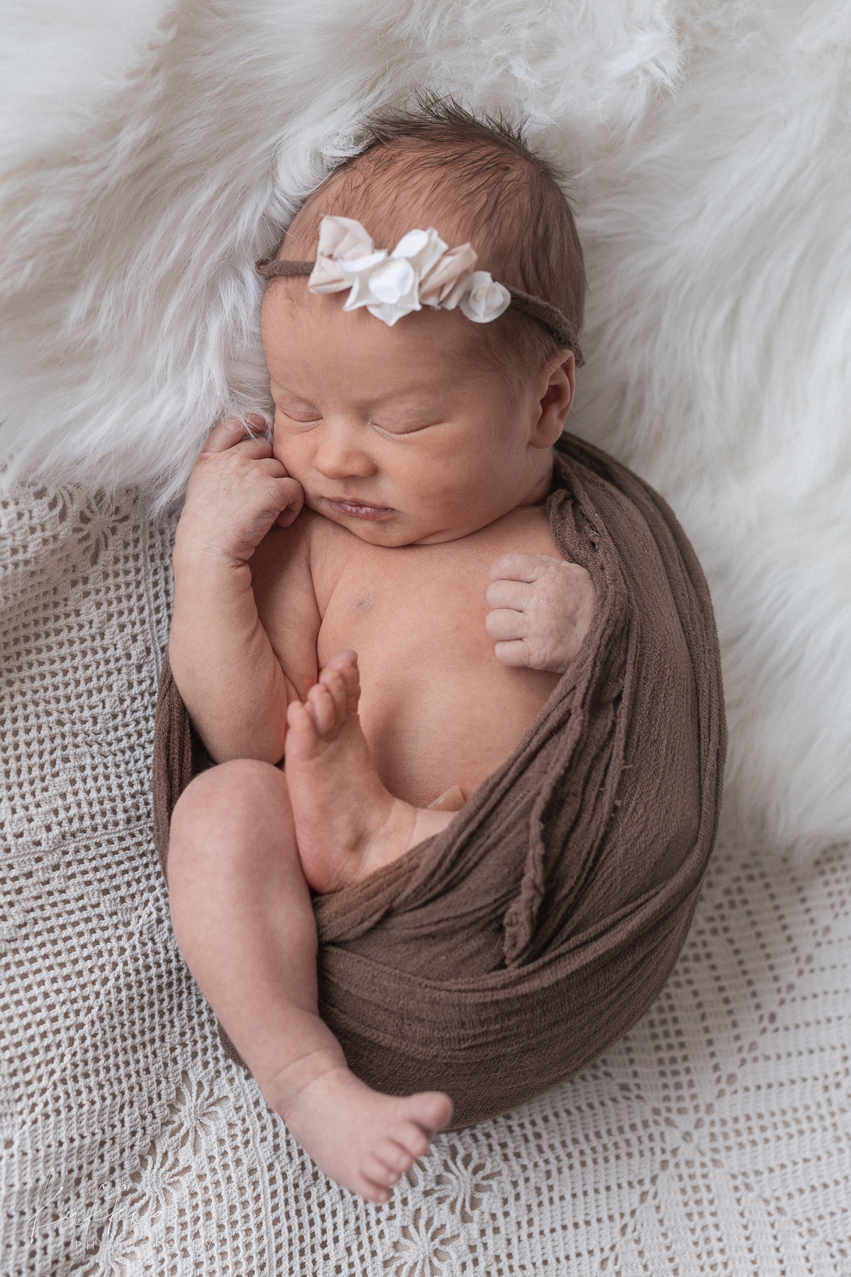 newborn-kuvaus-vauva-panta-ruskea-savy.jpg Vastasyntynyt vauva pannalla kapaloituna ruskeaan sävyyn newborn-kuvauksessa