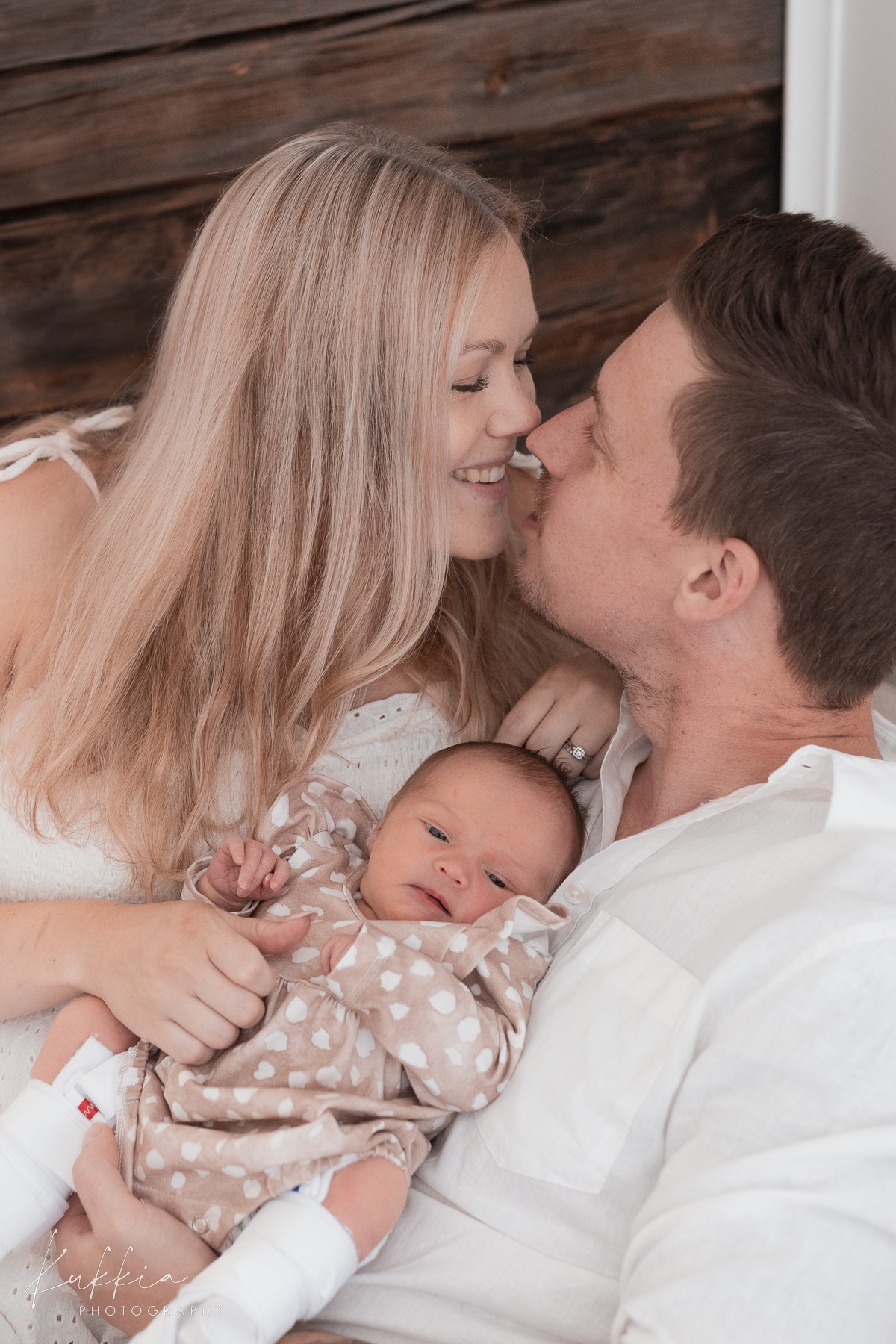 newborn-perhekuvaus-aiti-isa-vauva-hetki Vanhemmat sylittelevät vastasyntynyttä vauvaa perhekuvauksessa