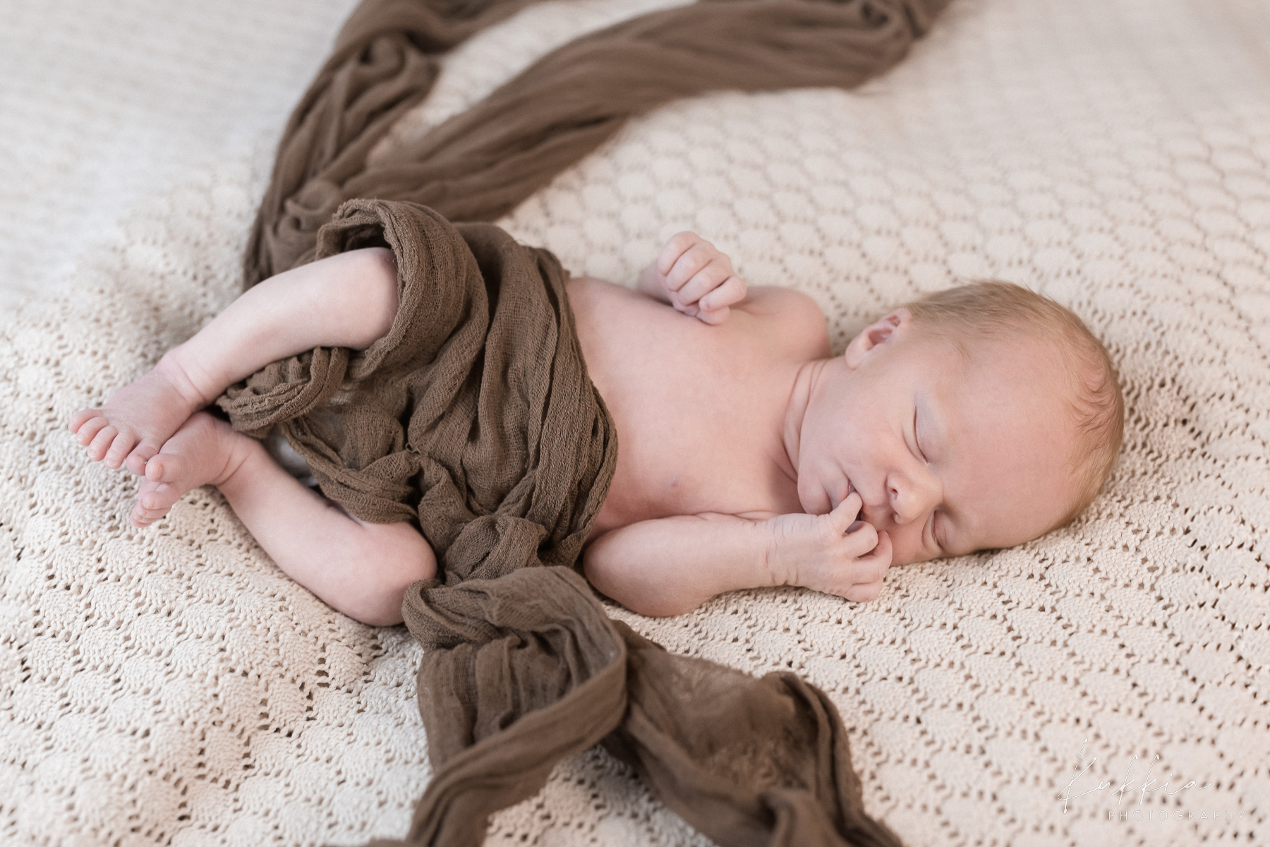 newborn-kuvaus-vauva-luonnollinen-poseeraus.jpg Vastasyntynyt vauva makaa pehmeällä alustalla luonnollisessa asennossa