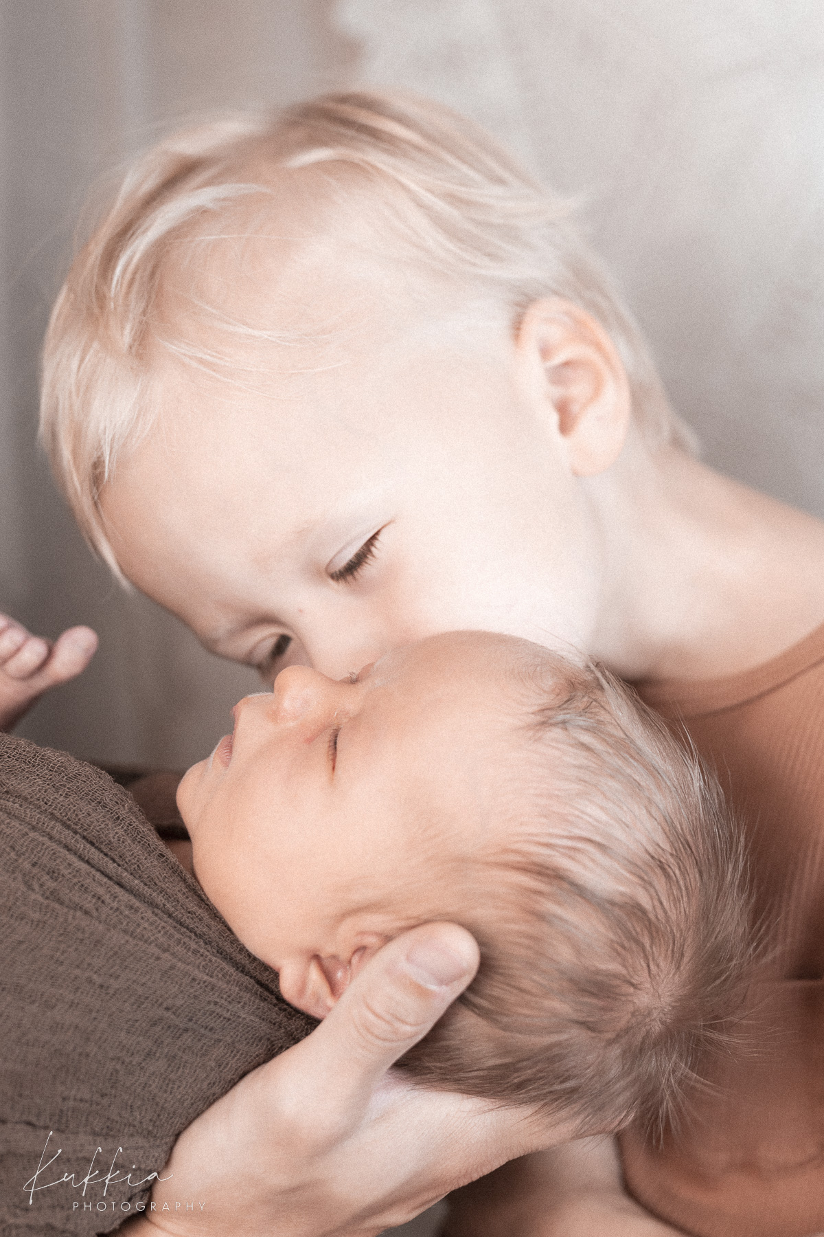 newborn-kuvaus-sisarus-vauva-hameenlinna.jpg Isosisarus suukottaa vastasyntynyttä vauvaa newborn-kuvauksessa Hämeenlinnassa